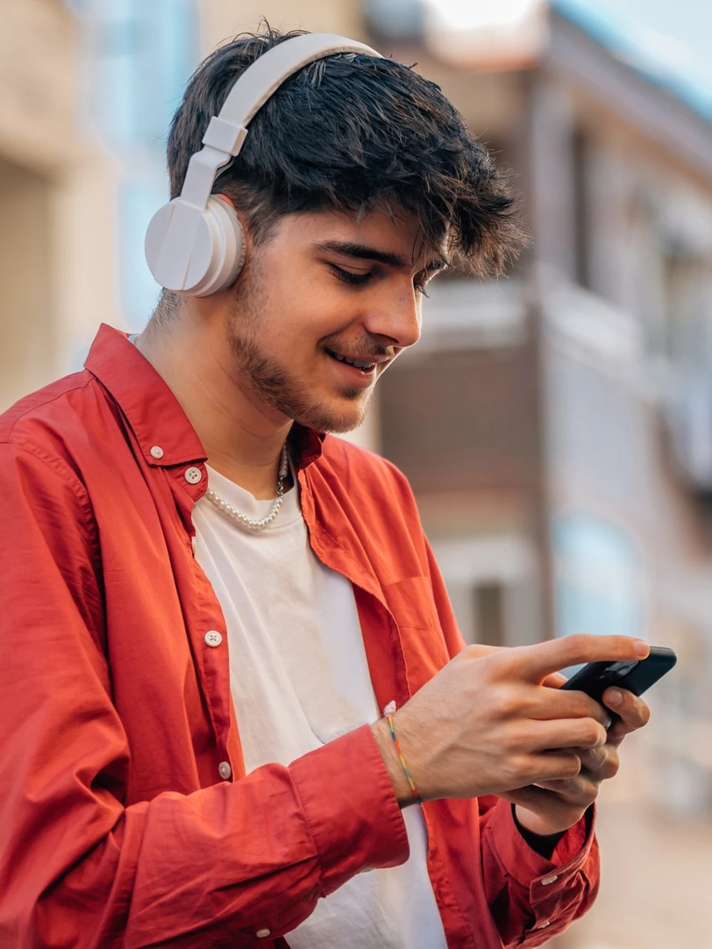 A creator listening through headphones while using their phone